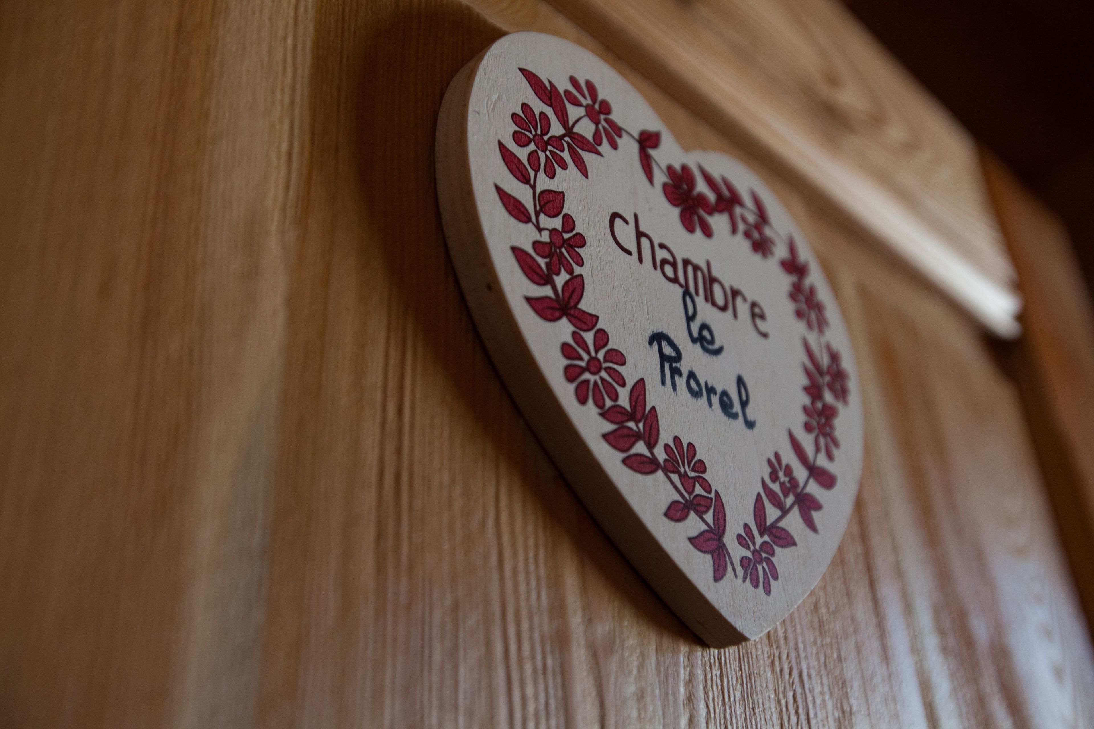 A wooden plaque with floral designs and the text "Chambre le Porol".