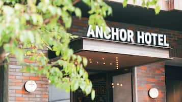 The exterior of Anchor Hotel with a brick facade and a sign above the entrance.