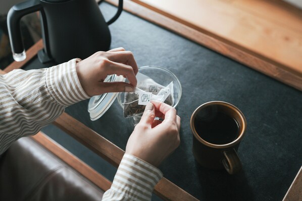 A person preparing a beverage with a kettle and a cup on a table. - Anchor Hotel Fukuyama (Fukuyama)