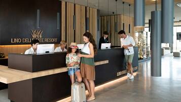 A reception desk at Lindo Del Lago Resort with a modern design, including vertical wooden slats and a dark reception area.
