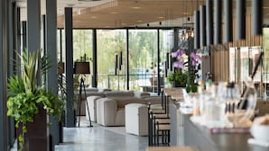 A modern interior with a seating area, large windows, and a bar.