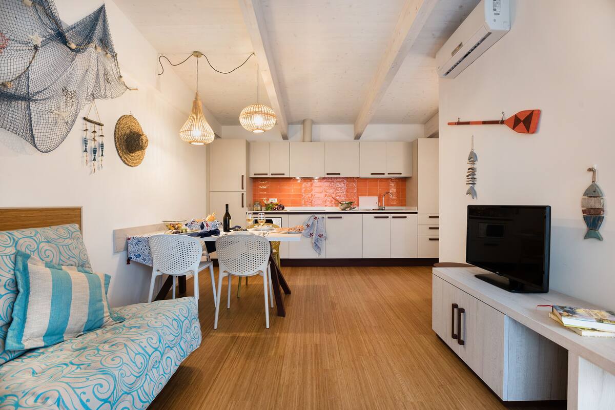 A compact living space with a kitchenette, a dining area, and a TV.