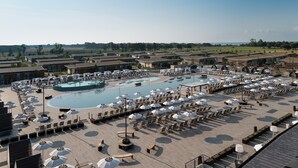 A resort with multiple swimming pools, sun loungers, and umbrellas.