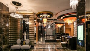 Un hall d’entrée luxueux, avec un sol en marbre, de magnifiques lustres et un design moderne.