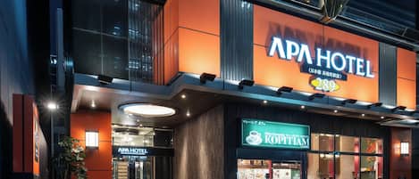 The APA HOTEL with a modern facade, a KOPITIAN restaurant, and a visible entrance.