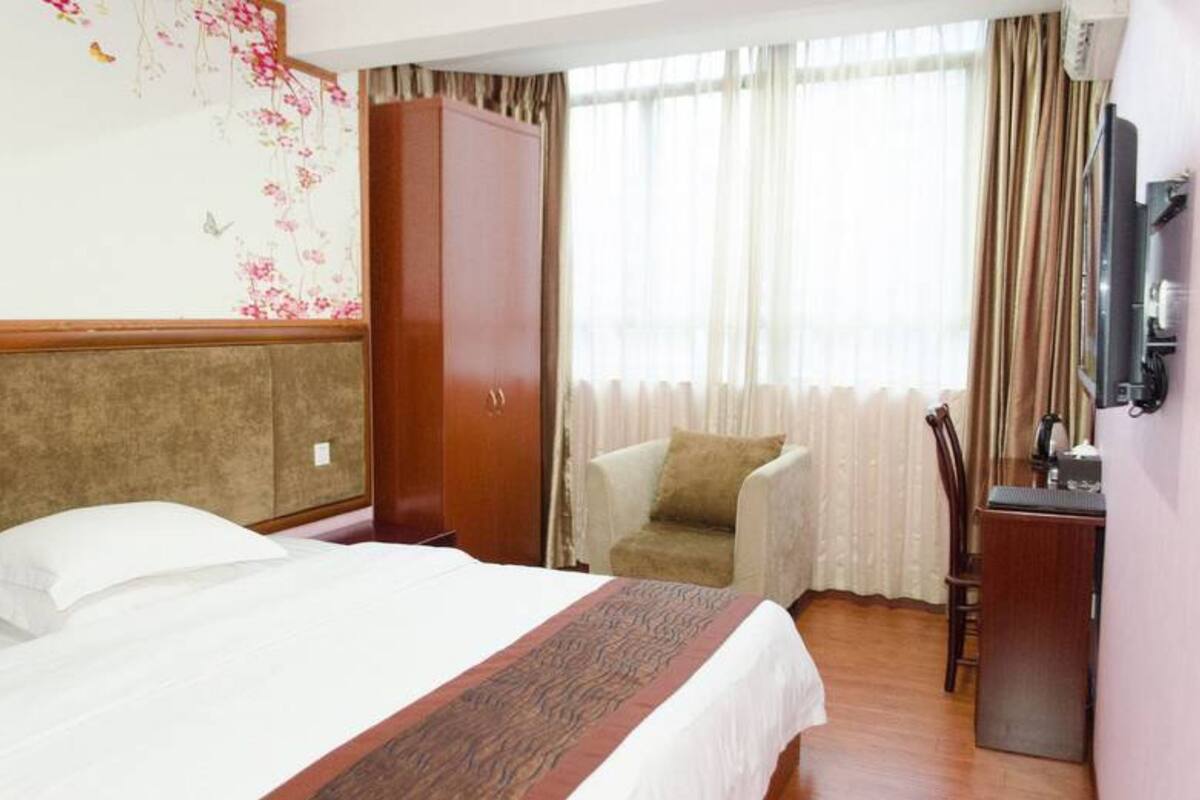 Una habitación de hotel con cama, armario, escritorio y silla.