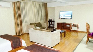 A hotel room with two beds, a sofa, a TV, and a desk. - Jintang Hotel Guangzhou (Guangzhou)