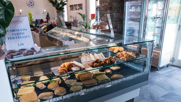 A bakery display case with various baked goods and a sign indicating a price of 2.50 for a cornetto per celiaci. - B&B Silvia (Vecchiano)