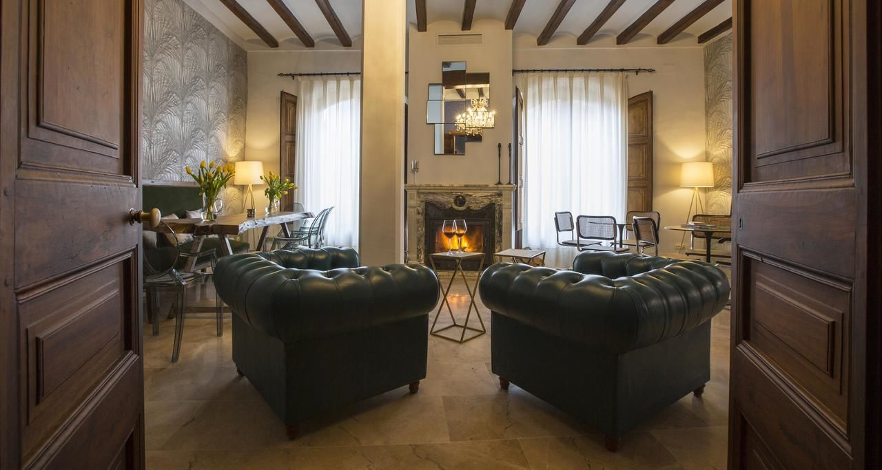 Una sala de estar acogedora con dos sofás de cuero, una chimenea y un comedor con mesa y sillas.