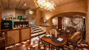 Un restaurante con un interior rústico, que cuenta con una barra de madera, un suelo de patrón hexagonal y una lámpara original.