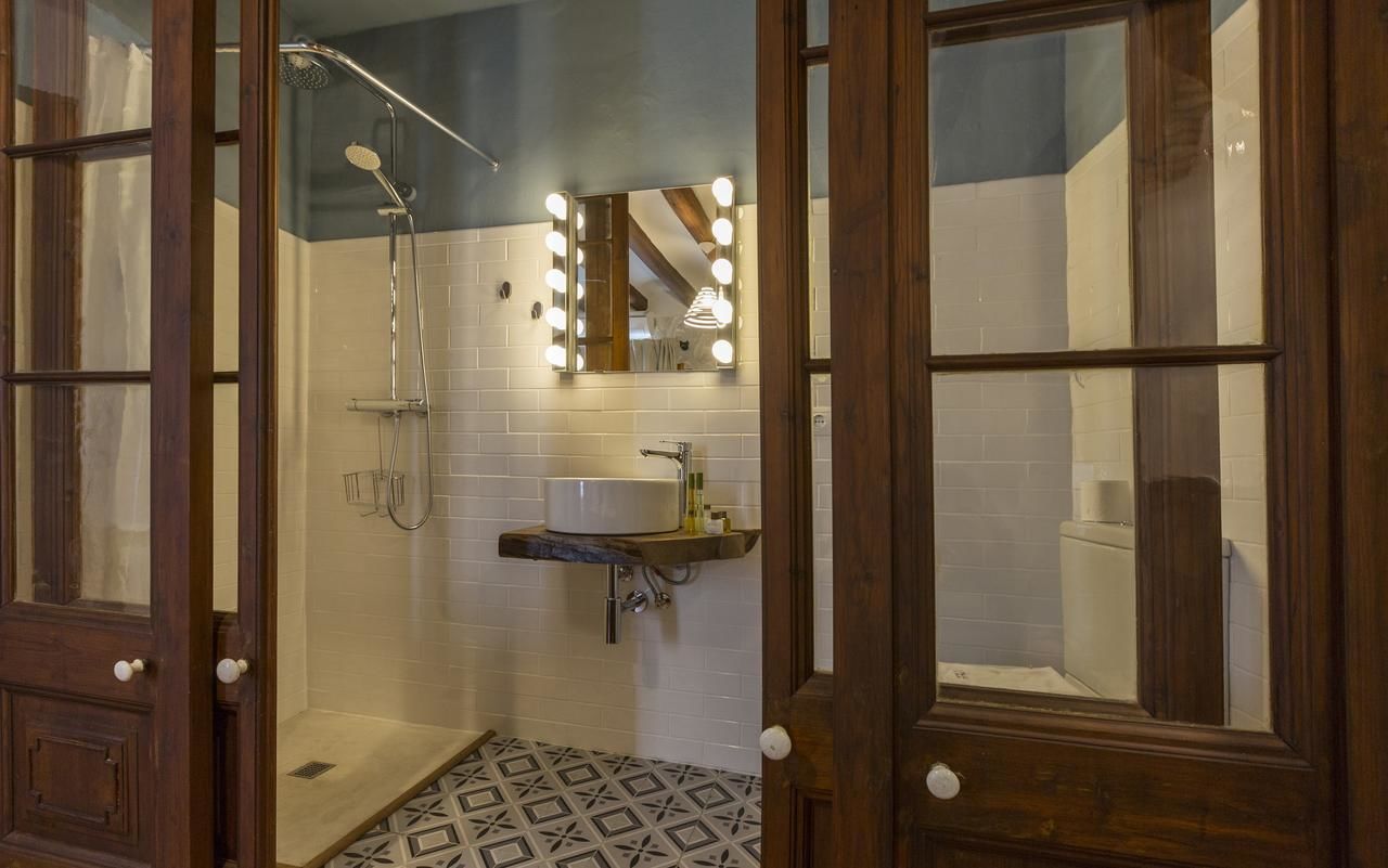Un baño con ducha, lavabo y espejo con iluminación.