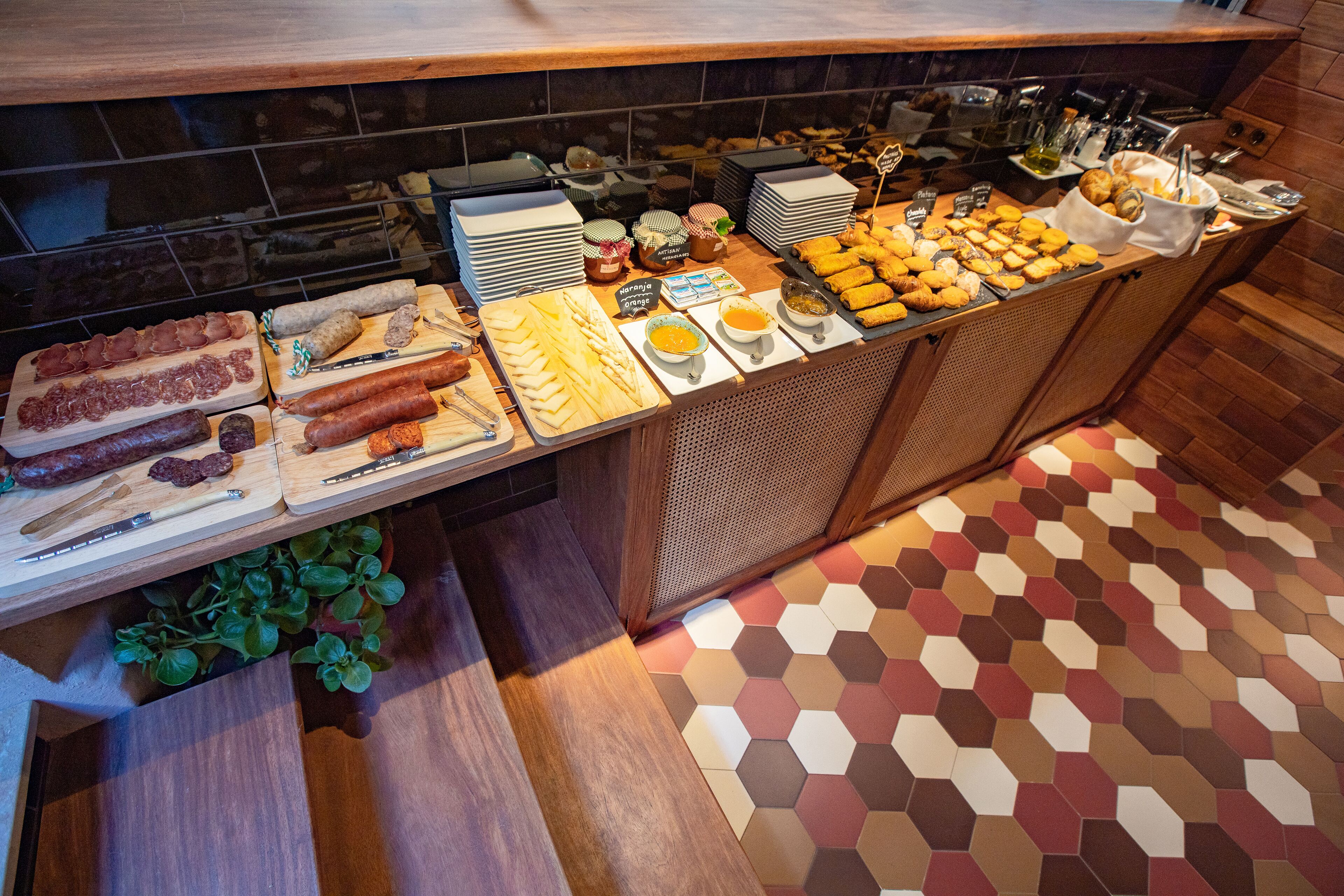 Un bufé con una variedad de alimentos, incluyendo carnes, quesos y pasteles.