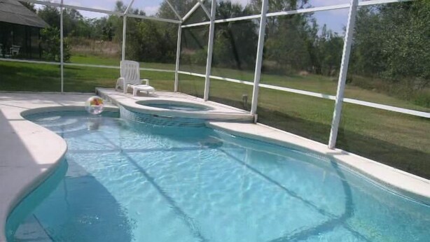 A swimming pool with a hot tub, surrounded by a covered area with chairs. - Ly53774 - Indian Ridge - 4 Bed 2 Baths Villa (Kissimmee)