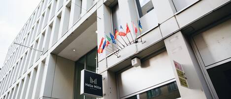 A modern building with a sign for 'Helle Mitte Hotel'.