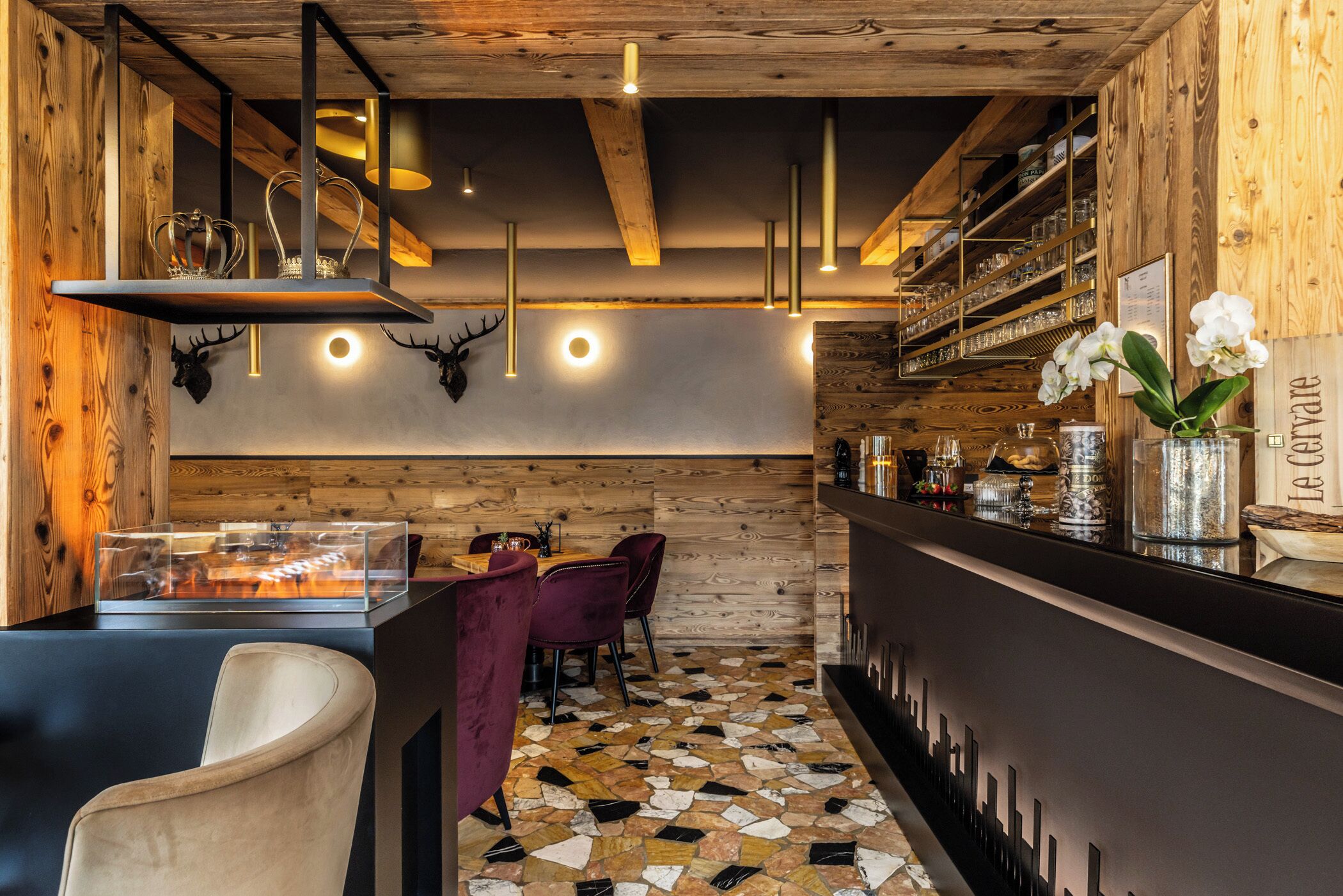 A bar area with a wooden interior, a tiled floor, and a bar counter with various items.