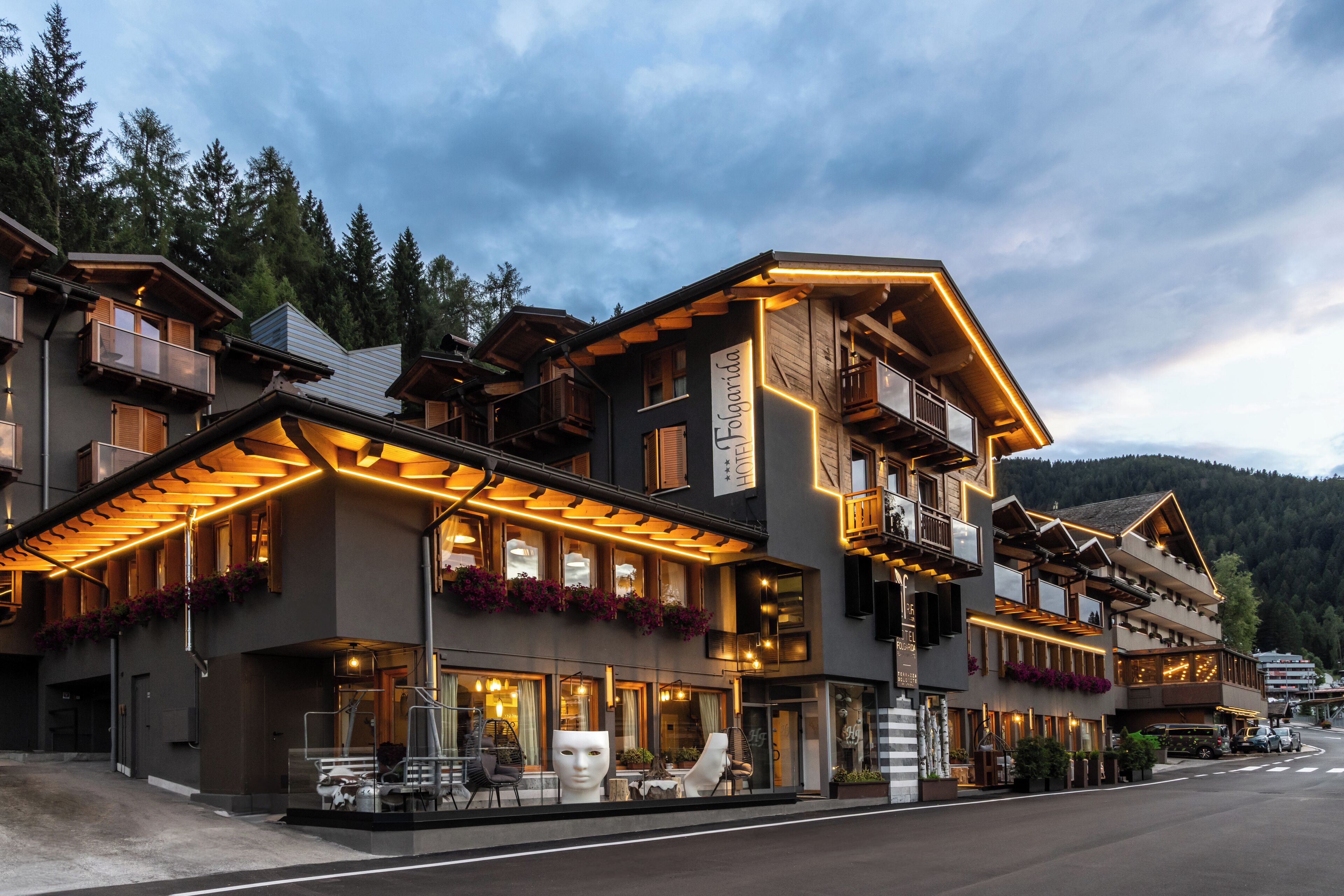 Un hotel de varios pisos con balcones, ventanas amplias y zonas de estar al aire libre.