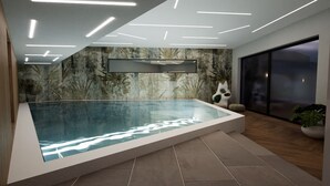 Une piscine intérieure moderne dotée d’un fond en verre, entourée d’un sol carrelé, d’un mur orné d’une fresque tropicale et d’un plafond pourvu d’un éclairage linéaire.