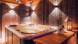 Un bain à remous dans un chalet en bois, avec une lanterne sur le côté.