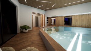 Un espace piscine intérieur moderne, doté d’un plancher en bois, d’une piscine à parois de verre et d’une plante en pot.