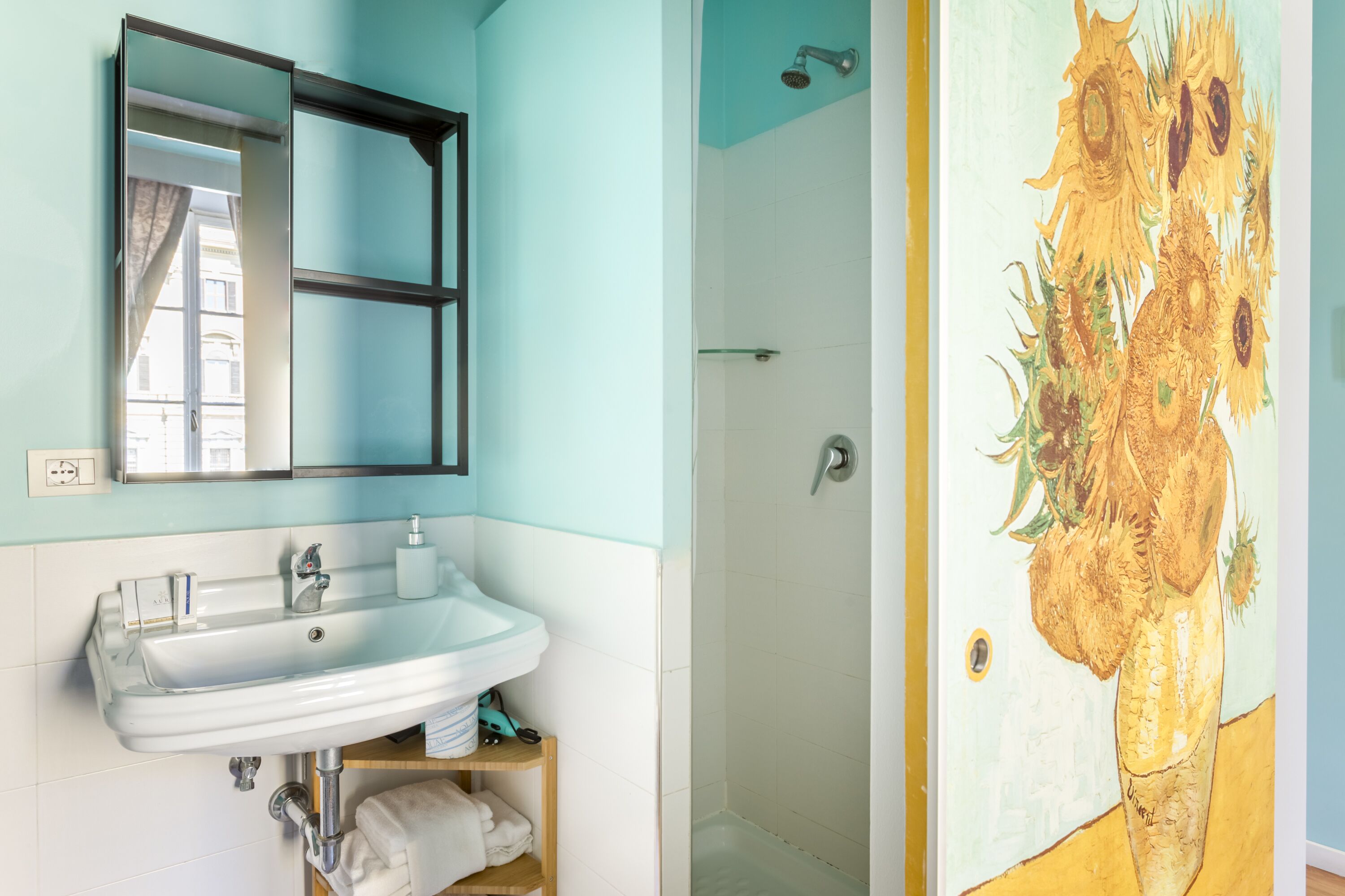 Un bagno con lavandino, specchio e doccia bianchi.