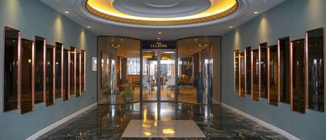 A hotel lobby with a marble floor, a circular ceiling design, and a sign reading "CAFE LA LATINA".