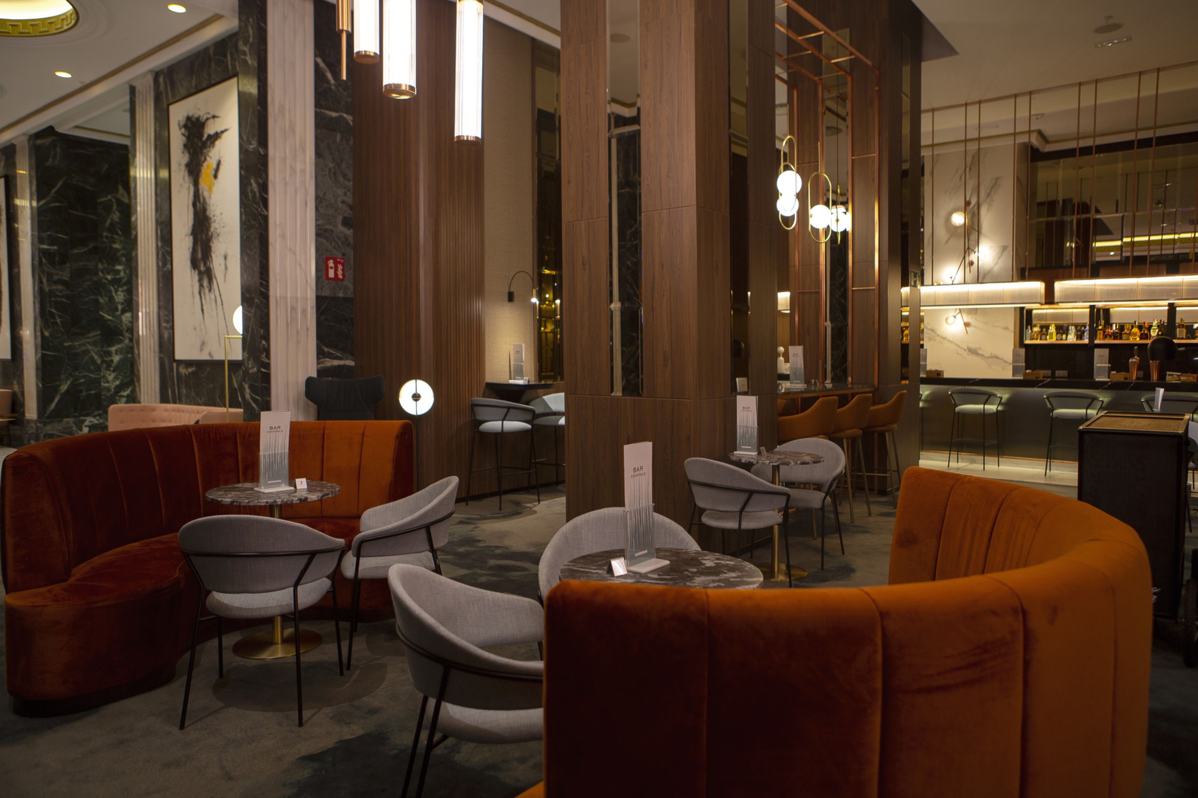 A modern interior with seating arrangements, a bar area, and a marble wall.