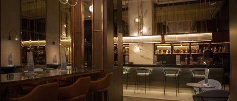 A modern bar area with seating and a bar counter.