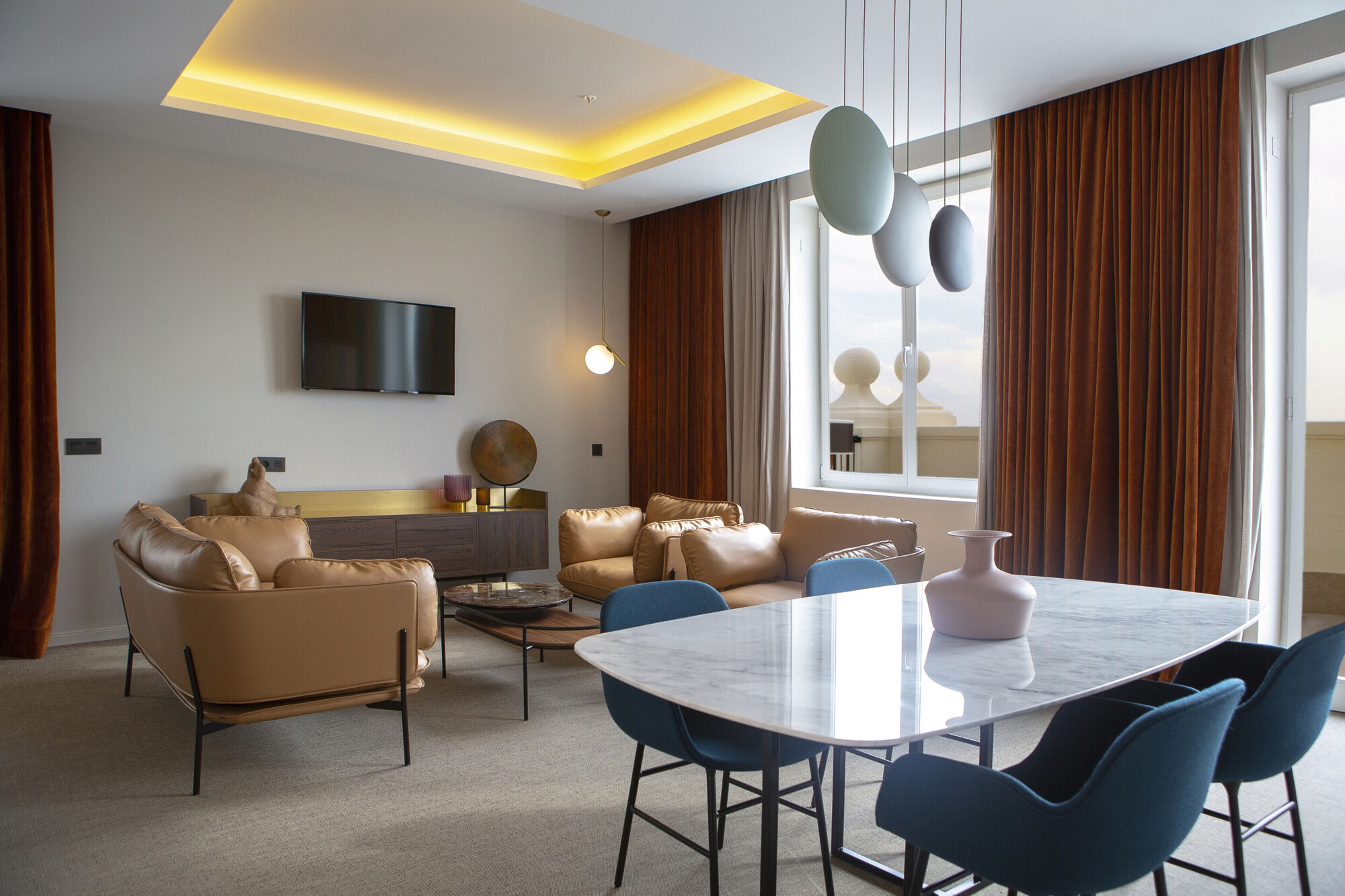 Un salon moderne avec un canapé, une table basse et un téléviseur fixé au mur.