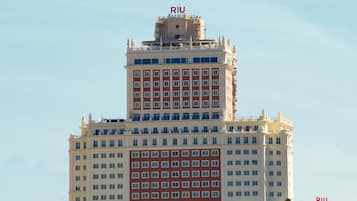 Un hotel de varios pisos con una torre central destacada y un edificio más pequeño a la derecha.