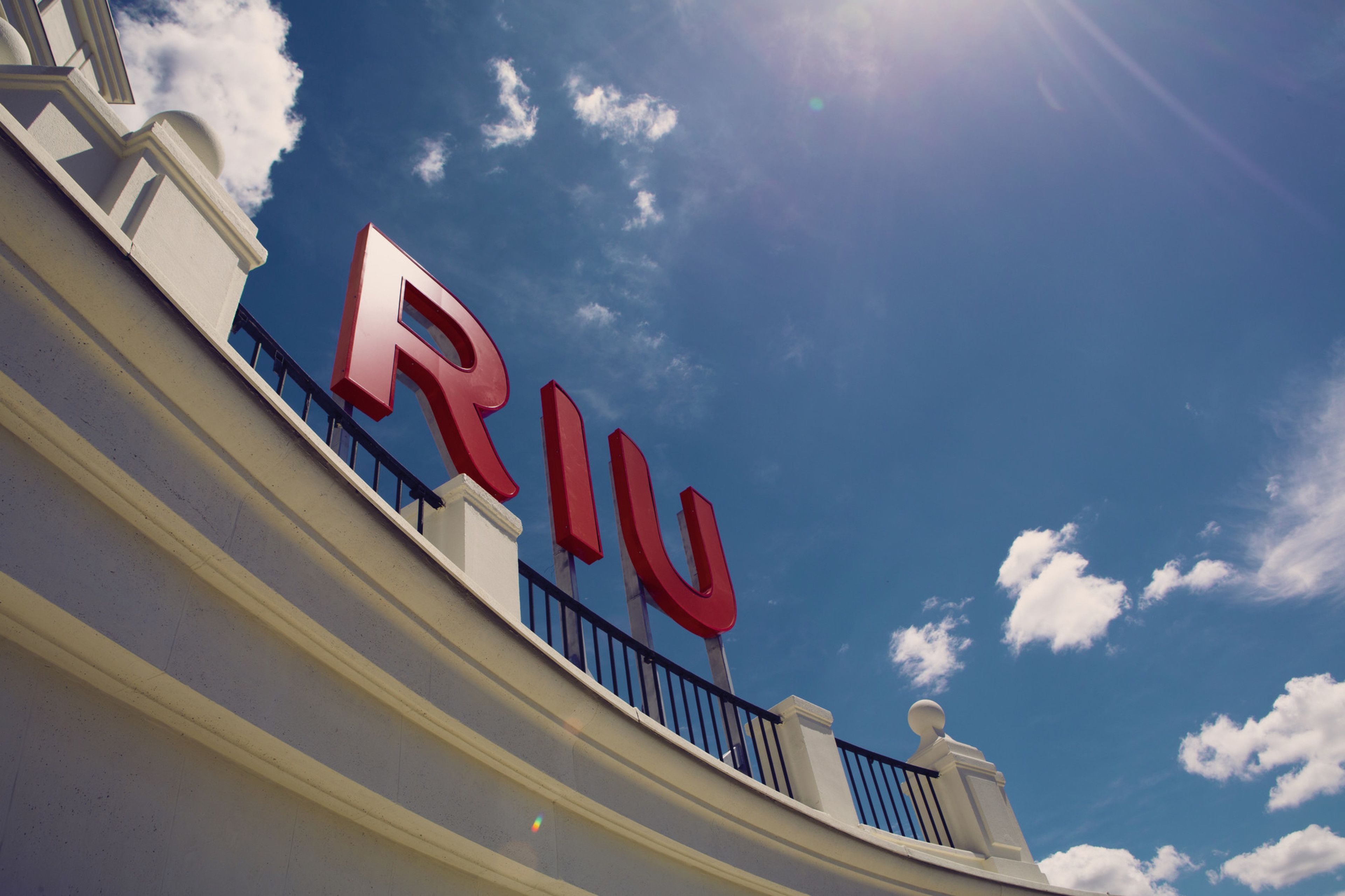 Un bâtiment sur lequel on peut voir un grand panneau rouge avec l’inscription « RJU » sur le balcon.