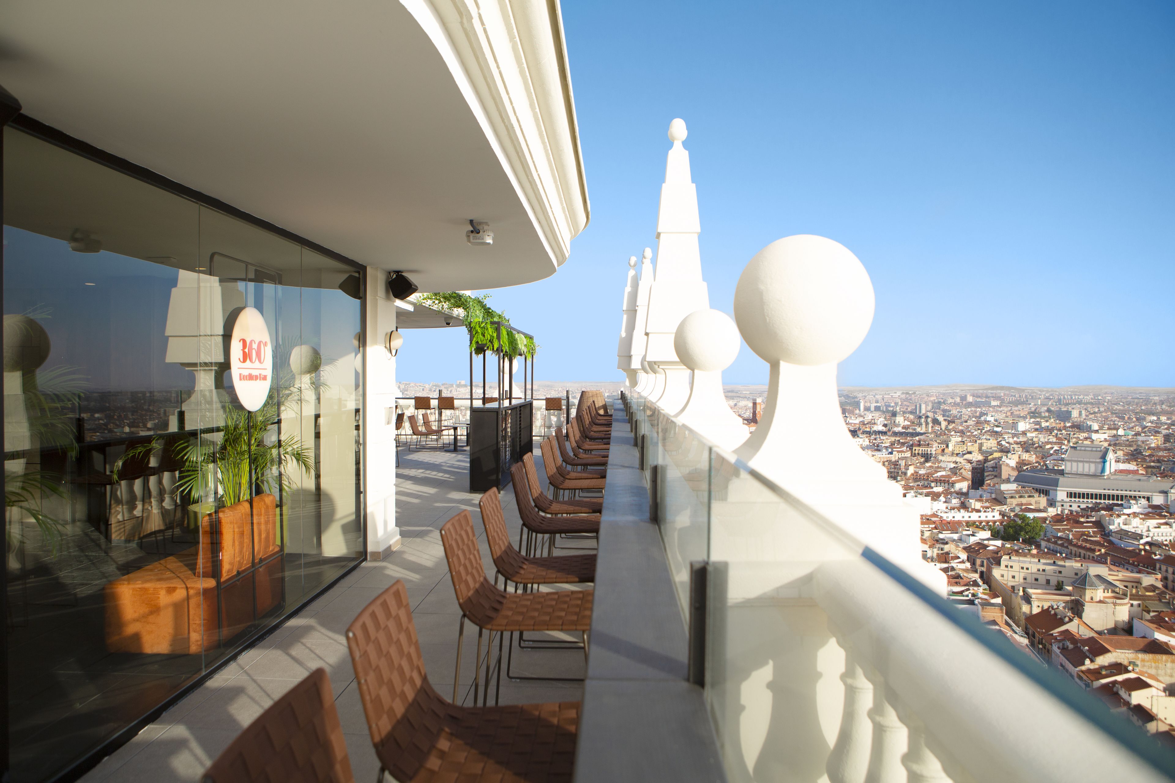 A rooftop terrace with seating and a view of the city.