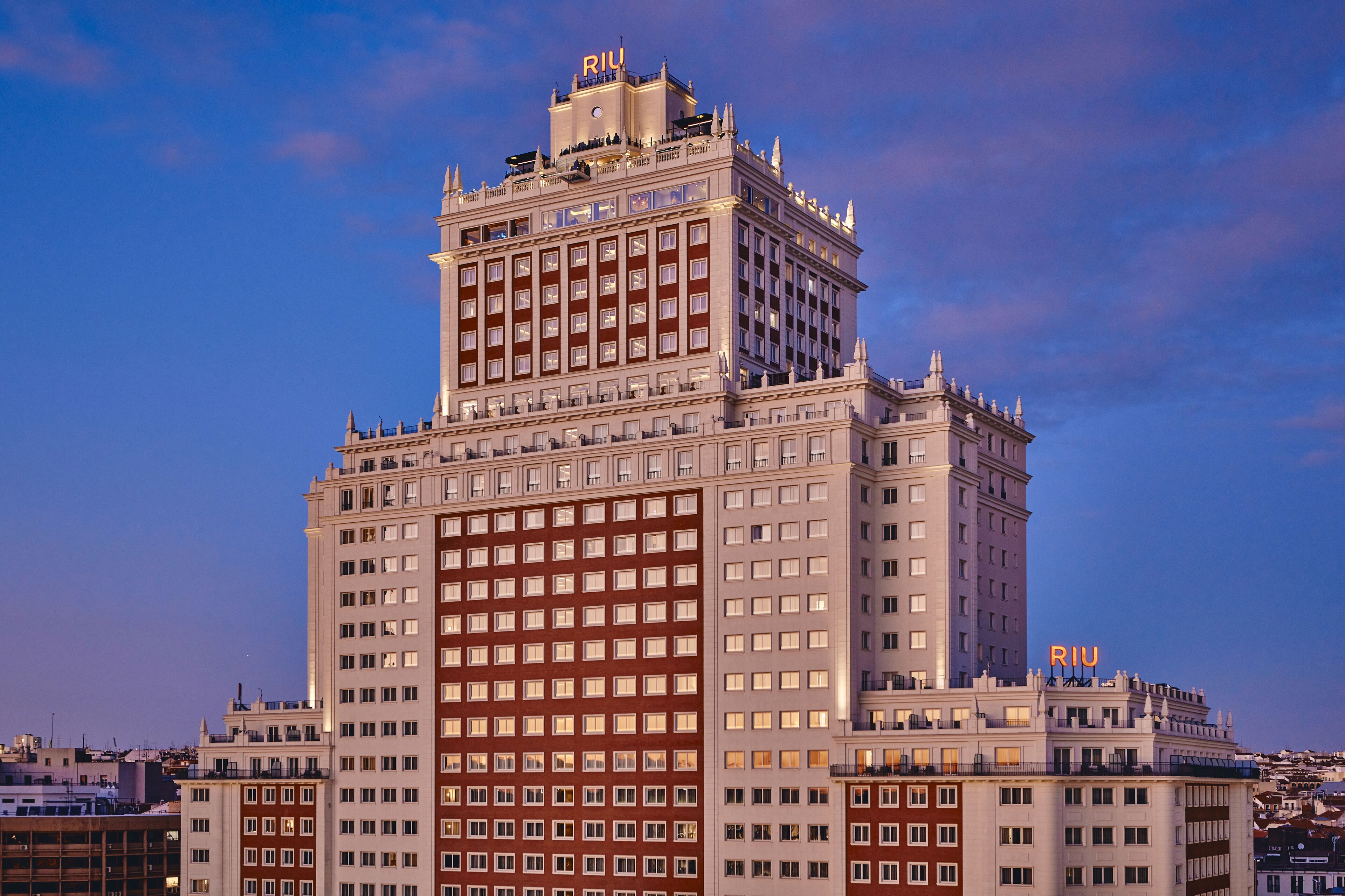 Un hotel grande de varios pisos con un letrero llamativo que dice 'RIU' en la parte superior.