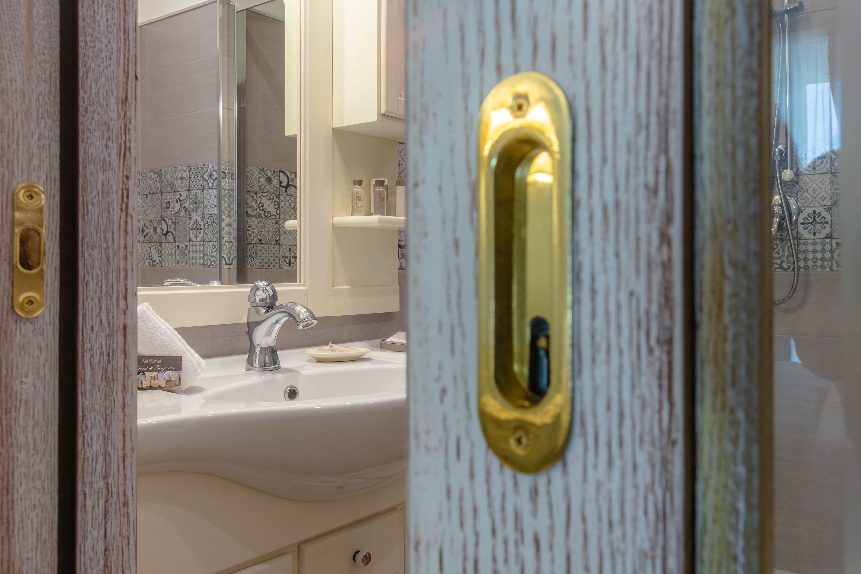 A bathroom with a white sink, a mirror, and a shower area.