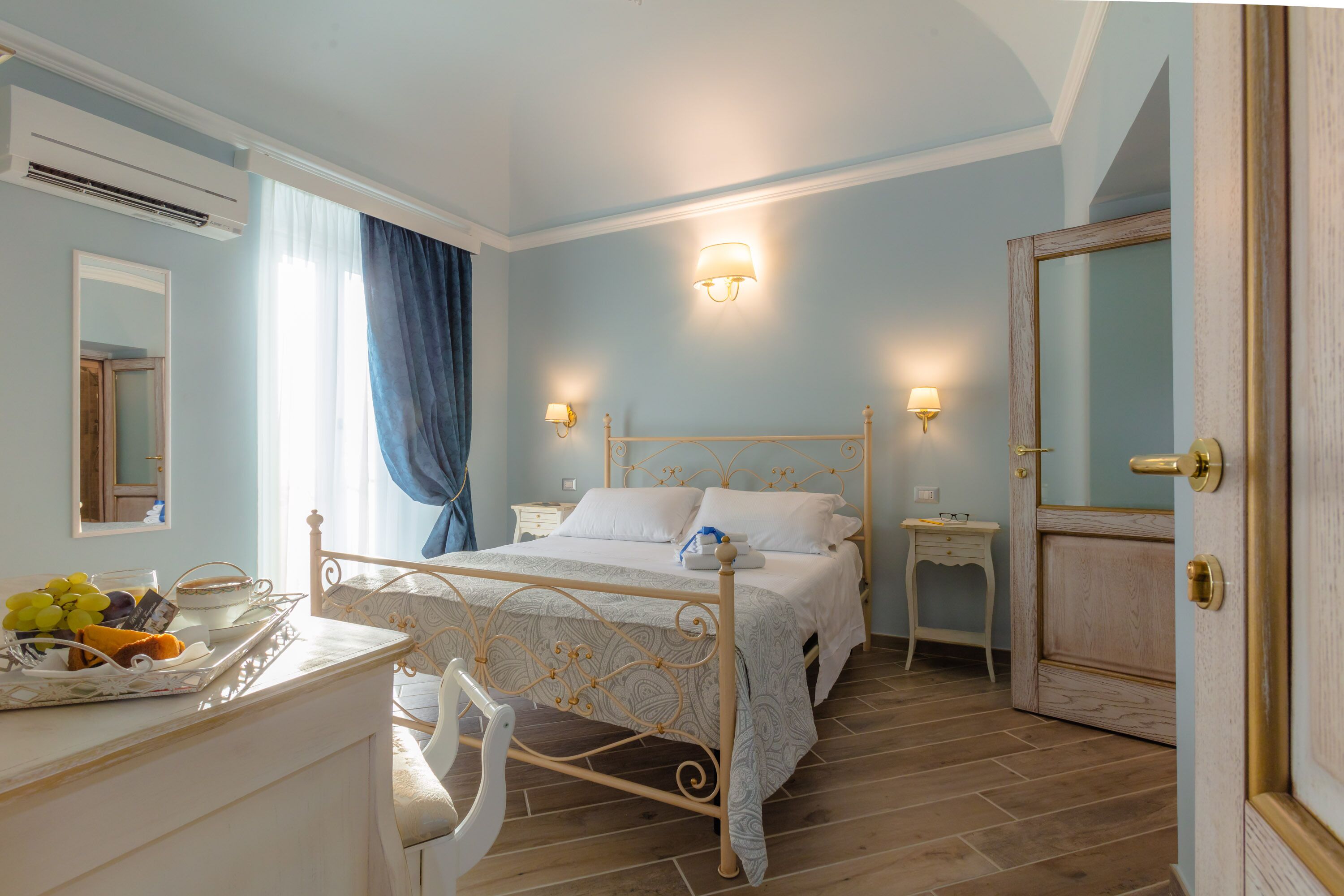 Une chambre à coucher avec un lit, des tables de chevet, une commode et un miroir.