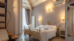 Ein Schlafzimmer mit einem Holzbett, Nachttischen, einem Sessel und einem Spiegel.