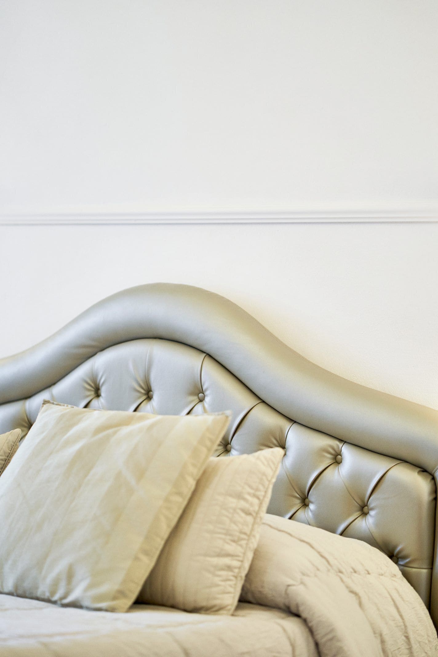 A bed with a tufted headboard and two pillows.