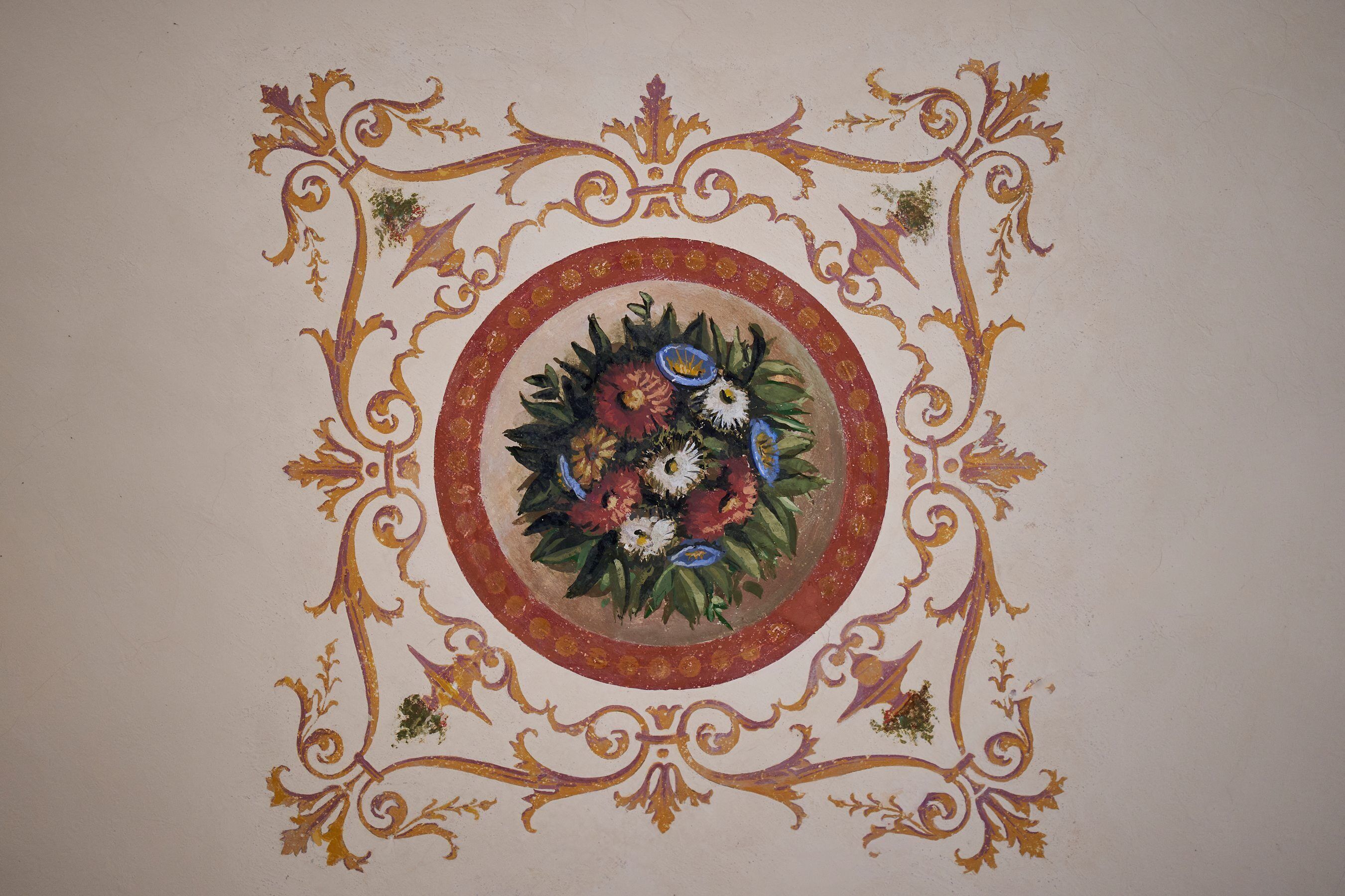 A detailed floral design with a circular motif and ornate patterns on a wall.