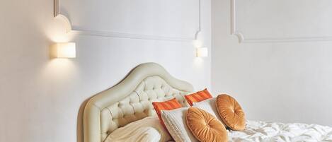Een slaapkamer met een bed, nachtkastje en wandlampen.
