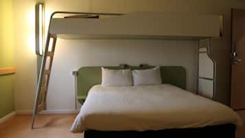 A bunk bed with a ladder, a bedside table, and a wall-mounted light fixture.