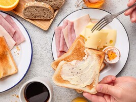 Desayuno con tostadas, jamón, queso y un huevo.