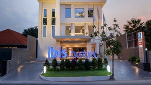 A modern hotel building with a prominent "ibis budget" sign, multiple floors, and a well-lit entrance. - ibis budget Surabaya Diponegoro (Surabaya)