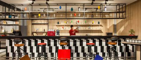 A modern bar area with multiple stools, a counter, and shelves stocked with bottles and glasses.