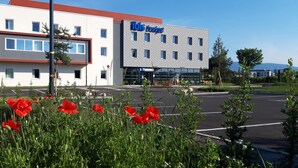 A modern hotel building with a flat roof, multiple windows, and a sign reading "ibis budget". - Ibis Budget Saint Genis Pouilly Geneva (Saint-Genis-Pouilly)