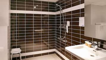 Een badkamer met een douche, wastafel en toilet.