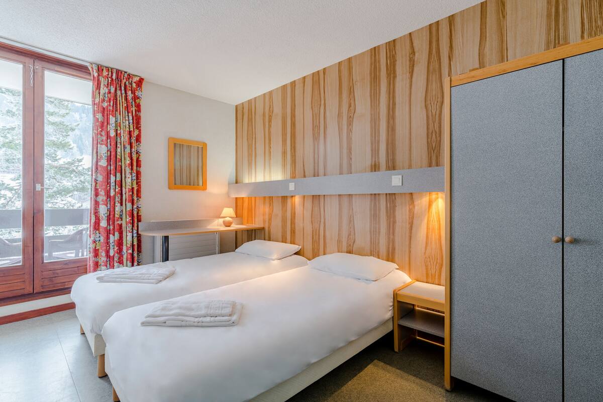 A double bed with a wooden headboard and a wardrobe.