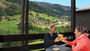 A terrace with a table and chairs overlooking a village and mountains. - Azureva Areches Beaufort (Beaufort)
