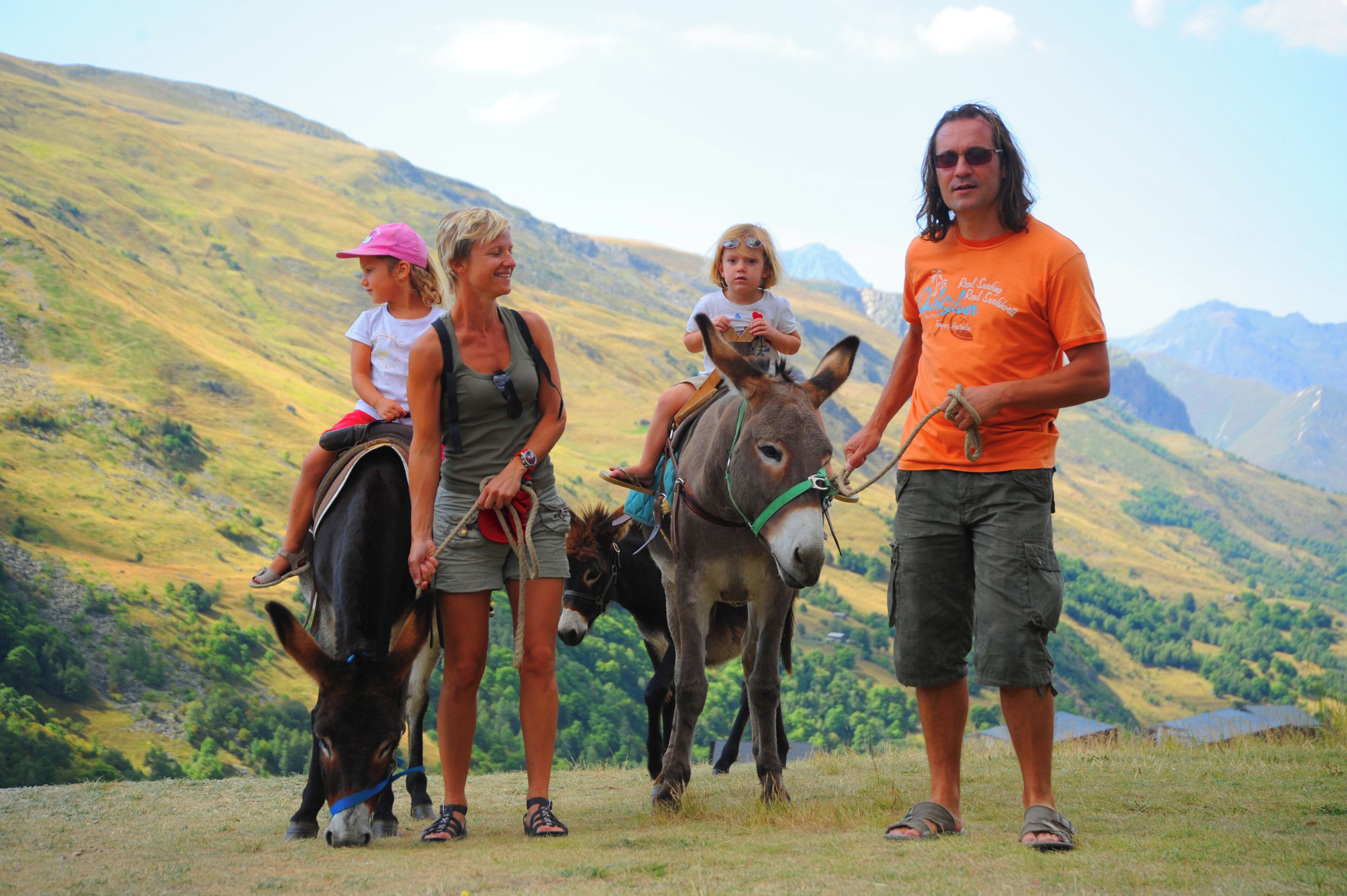 A group of people with donkeys in a mountainous area.