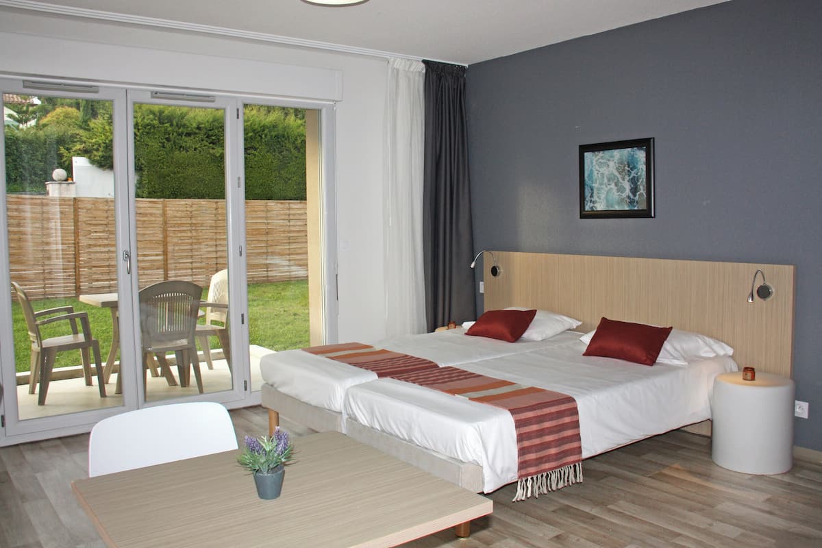 Un lit double avec des oreillers rouges, une tête de lit en bois et une table de chevet avec une lampe.