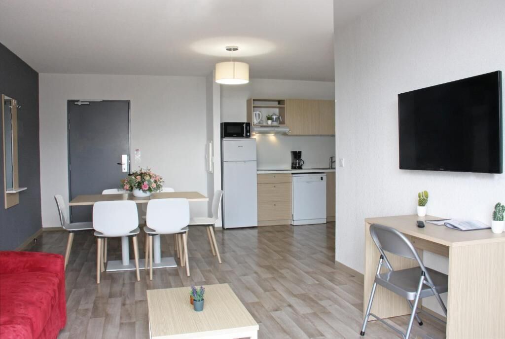 Apartamento moderno com área de refeições, cozinha e espaço para trabalho.