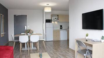 Un appartamento moderno con zona pranzo, cucina e angolo studio.